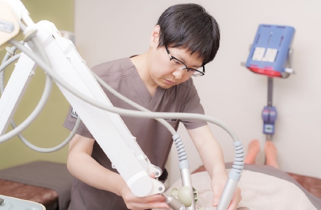 最新の医療機器を用いて施術を行うスタッフの様子。集中して丁寧に治療にあたっています。