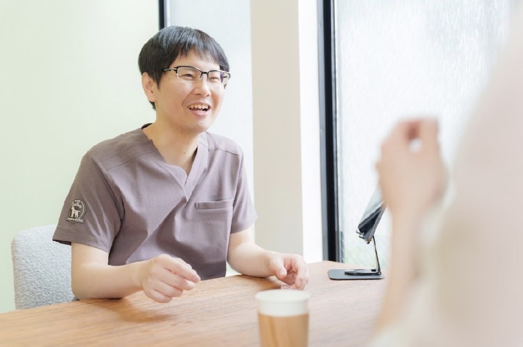漢方相談のイメージ。笑顔で話を聞く施術者と、リラックスして相談する相談者。