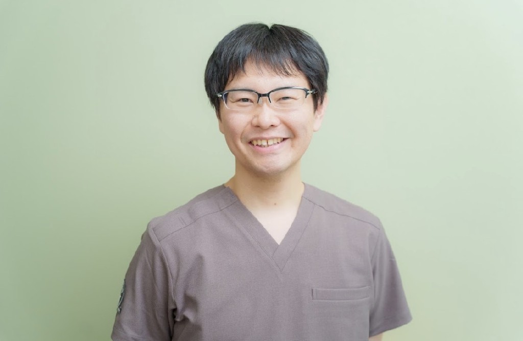 院長のポートレート。スクラブ姿で微笑んでいる様子。